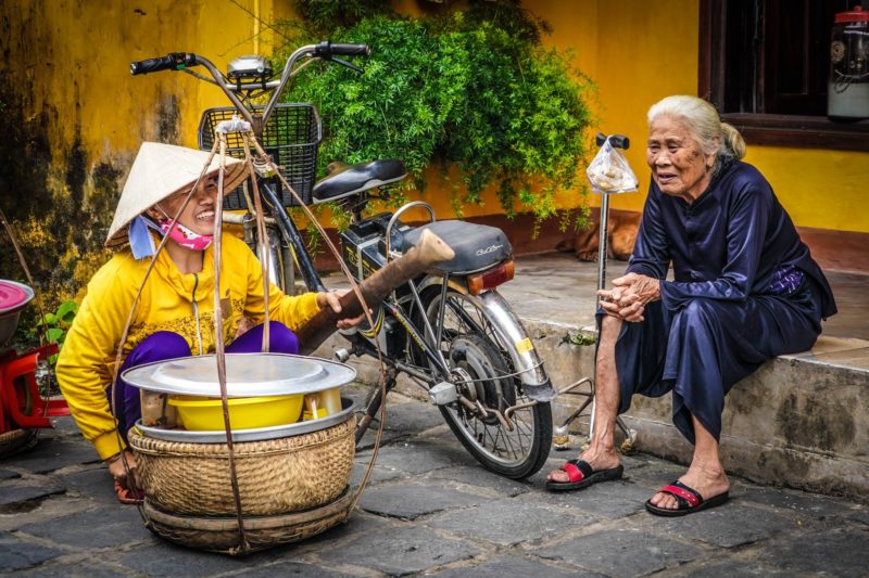 Vietnamese ladies chatting sieving rice